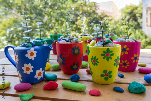 Multi colored painted flower pots on garden table