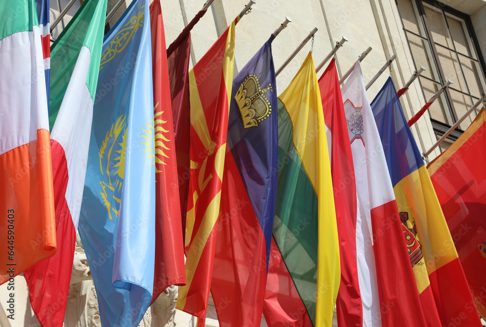flags of many world nations hanging outside government building with no people