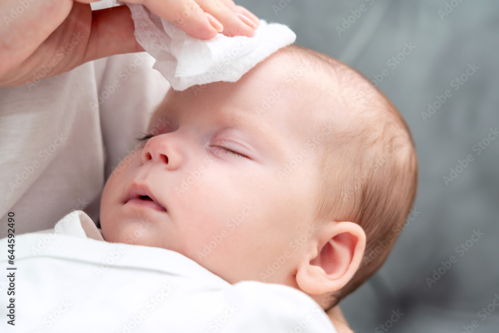 Wet wipe brings relief to newborn, Concept of maternal instinct during health concerns Wet wipe brings relief to newborn, Concept of maternal instinct during health concerns