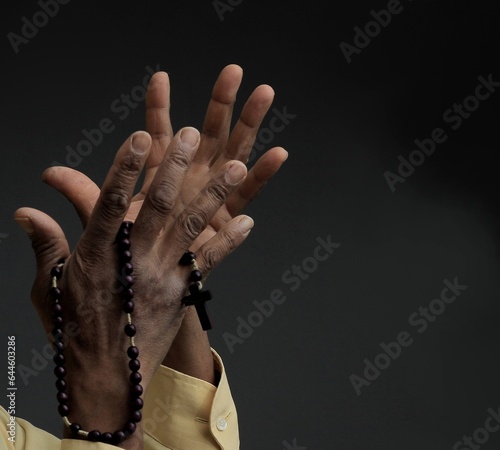 man praying to god with hands together on grey black background stock image stock photo	