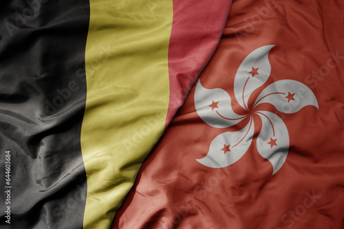 big waving national colorful flag of belgium and national flag of hong kong .