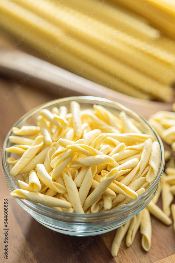 Fusilli pugliesi. Italian twisted pasta in bowl on wooden table. Fusilli pugliesi. Italian twisted pasta in bowl on wooden table.