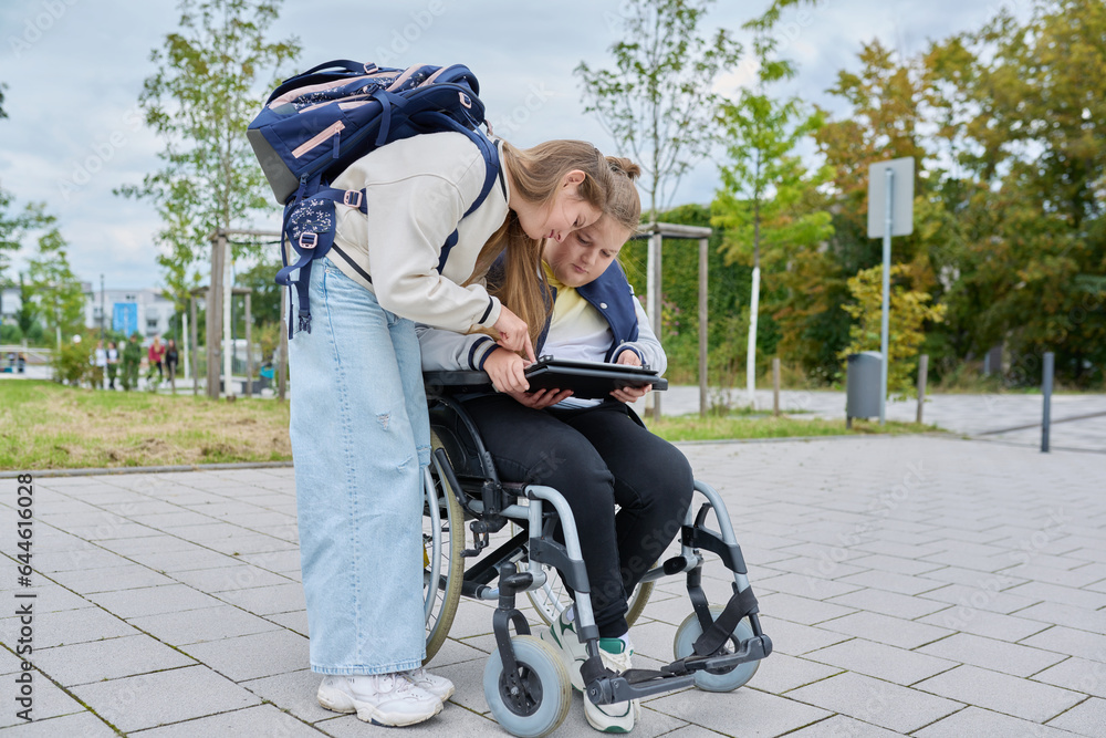 Obraz premium Children together outdoor, girl and boy on wheelchair talking near school building
