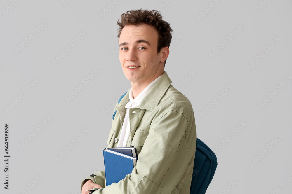 Male student with backpack and books on grey background Male student with backpack and books on grey background