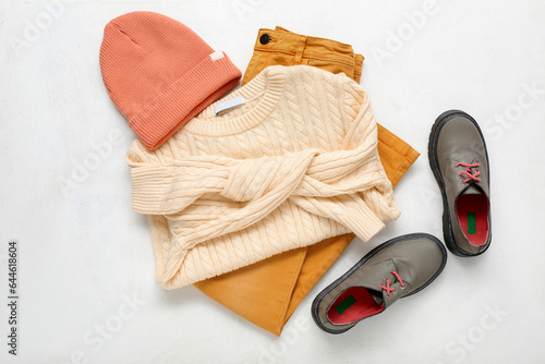 Set of stylish children's clothes and shoes on light background