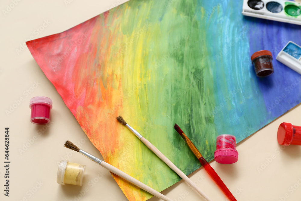Brushes, paints and painting on beige background Brushes, paints and painting on beige background
