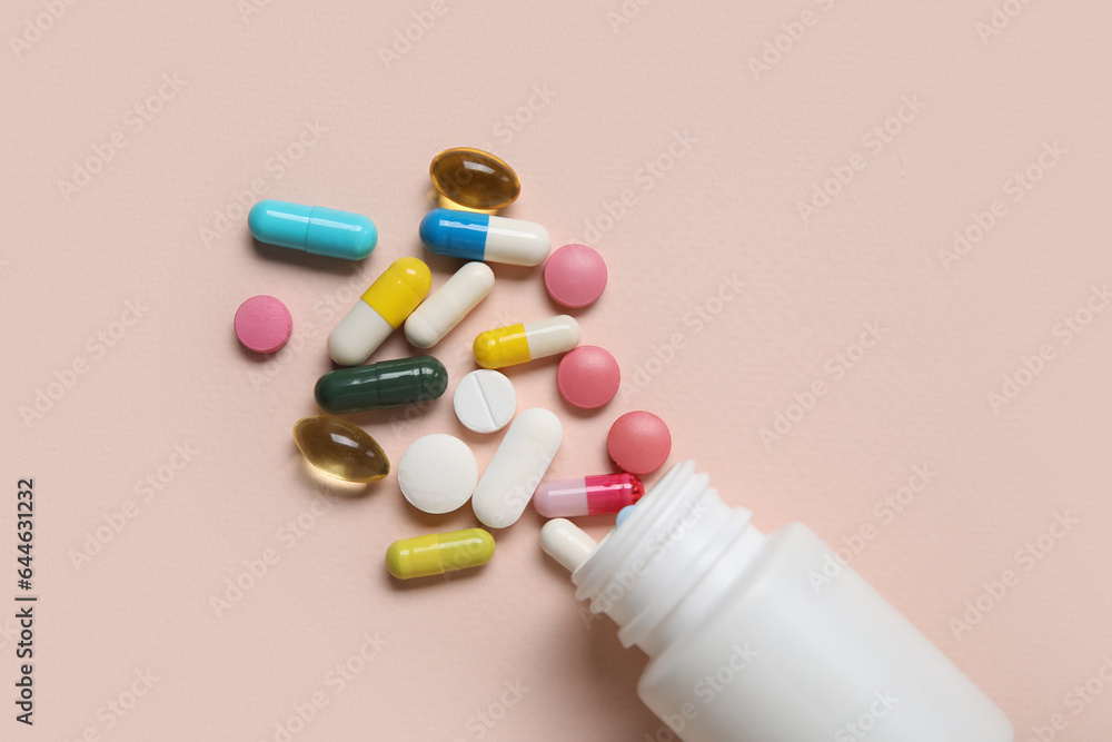 Jar with different scattered pills on beige background Jar with different scattered pills on beige background