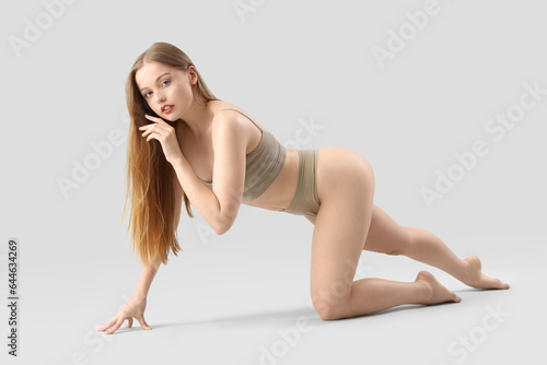 Beautiful woman in underwear on light background