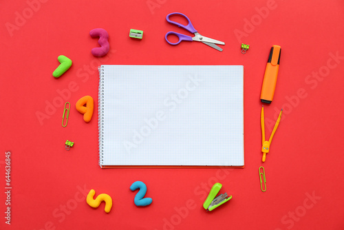 Composition with blank notebook, different stationery and numbers on red background