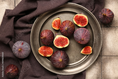 Plate with fresh ripe figs on grey tile background