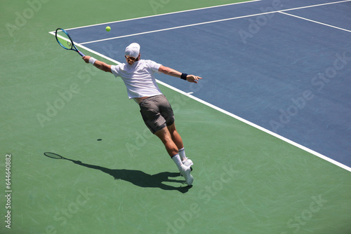 tennis player reaching for the ball, action shot