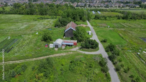 In this 15-second video, observe the relentless advance of urban expansion encroaching upon a dwindling farmstead. Filmed from a low-level drone perspective. photo