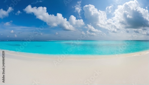 Sandy beach with white sand and rolling calm wave of turquoise ocean on sunny day, white clouds in blue sky background © ibreakstock