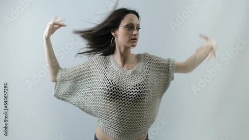 Urban and attractive girl dancing freestyle on white background