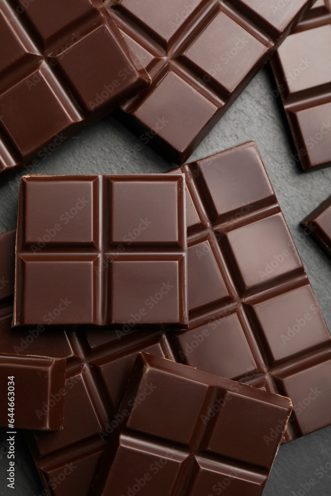 Delicious dark chocolate on black table, flat lay