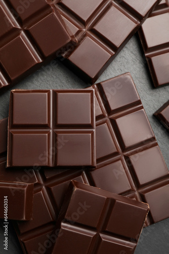 Delicious dark chocolate on black table, flat lay