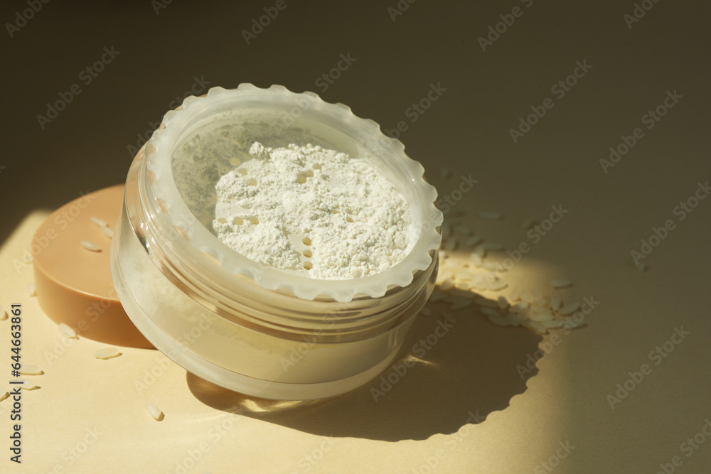Rice loose face powder on beige background, closeup. Space for text Rice loose face powder on beige background, closeup. Space for text