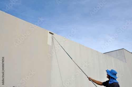 pintor pintando trabalhando em parede com pintura externa  photo