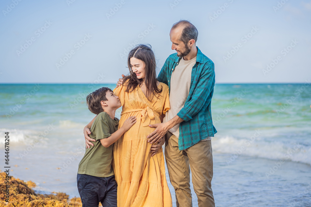 A loving family enjoying tropical beach - a radiant pregnant woman after 40, embraced by her husband, and accompanied by their adult teenage son, savoring precious moments together amidst nature's
