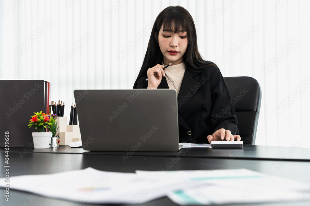 Young start up businesswoman working on notebook computer in office Young start up businesswoman working on notebook computer in office