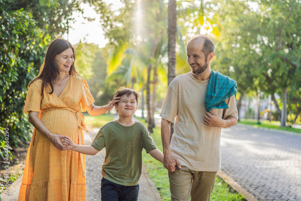 Naklejka premium A loving family enjoying a leisurely walk in the park - a radiant pregnant woman after 40, embraced by her husband, and accompanied by their adult teenage son, savoring precious moments together