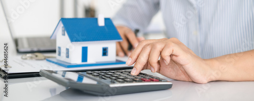 Buying and selling houses and real estate prices. Concept. Man using calculator to count rent money.