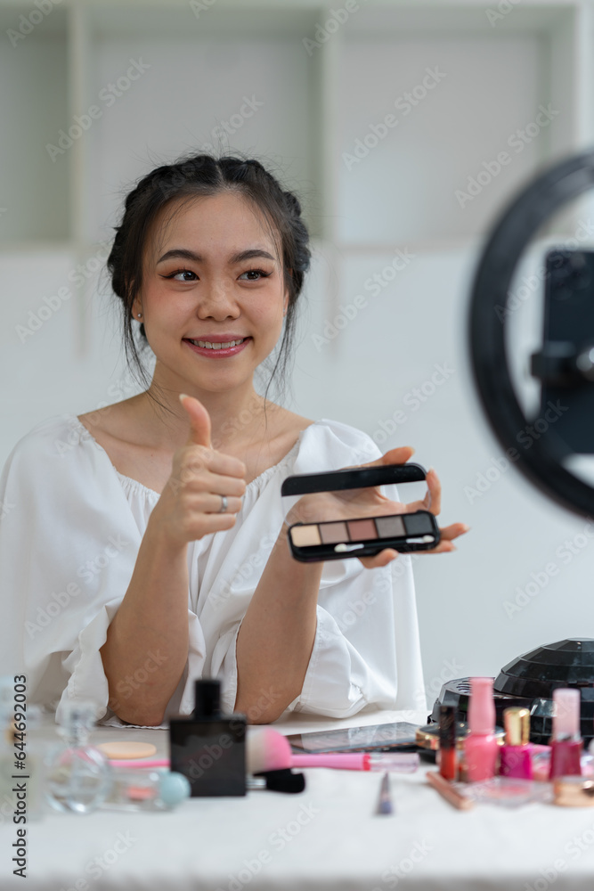 Asian beauty businesswoman live streaming makeup tutorial video clip Live selling cosmetics Perfume by camera sharing on social media, social media concept online sales online shopping.