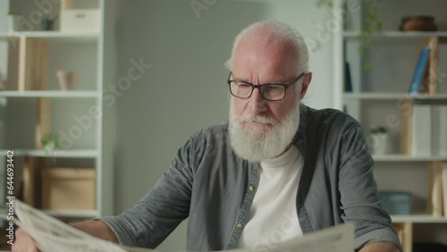 Wallpaper Mural A Serious, Smart Old Man Sits at a Table and Reads a Newspaper.An Elderly Man with a Newspaper Alone at Home, Sees the News and Current Events in the Newspaper.Daily Newspaper Concept Torontodigital.ca