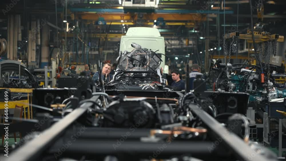 Automotive Equipment Production Facility. A Production Line is filled with multiple Vehicles Parts at the Automotive Factory. Workers are Supervising the Manufacturing Process at Automotive Plant. Automotive Equipment Production Facility. A Production Line is filled with multiple Vehicles Parts at the Automotive Factory. Workers are Supervising the Manufacturing Process at Automotive Plant.