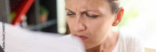 Focused woman trying read papers, squinting to see more clearly photo