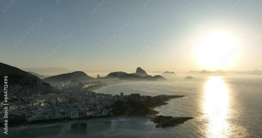 Sun shining on horizon at dawn in Rio, Copacabana Beach, Brazil. Aerial backwards Sun shining on horizon at dawn in Rio, Copacabana Beach, Brazil. Aerial backwards