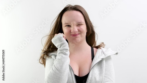Woman in a black shirt with a direct look of disappointment on a white background . High quality 4k footage