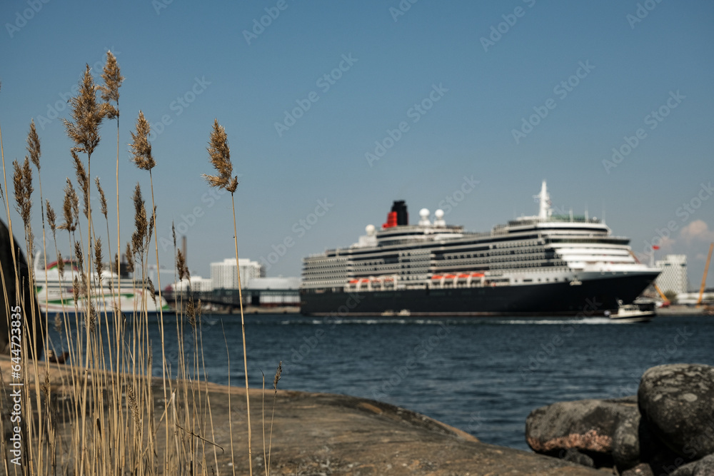Luxury British ocean liner cruiseship cruise ship in port of Helsinki, Finland during Baltic cruising with city skyline Luxury British ocean liner cruiseship cruise ship in port of Helsinki, Finland during Baltic cruising with city skyline