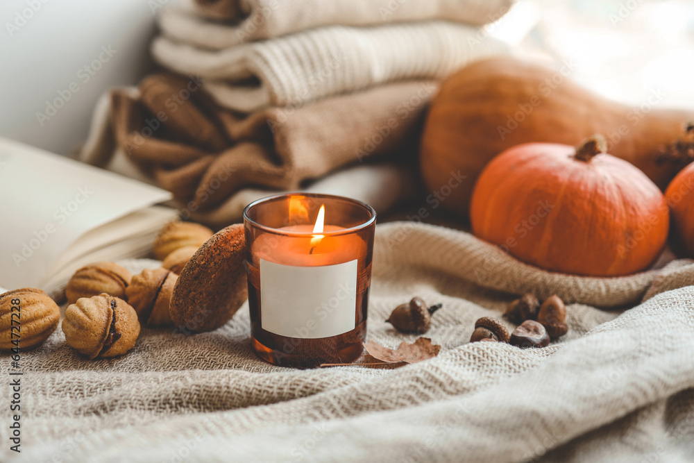 Burning candle with label isolated in autumn interior Burning candle with label isolated in autumn interior