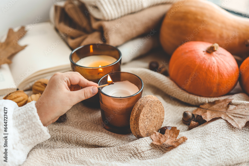 Match in hand lights a candle, cosiness concept Match in hand lights a candle, cosiness concept