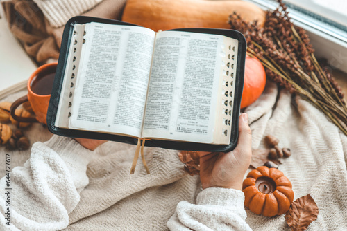 Photography Open Bible in female hands in autumn interior