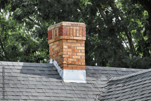 Foto An old chimney on a shingles rooftop.