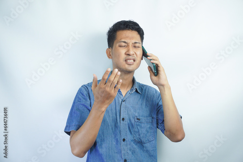 Portrait of angry young Asian business man serious frustrated getting angry argue while talking on mobile phone, communication conversation isolated on white background