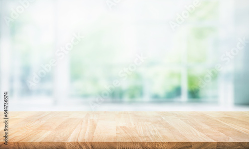 Selective focus.Empty of wood table top on blur of curtain with window and green from garden background.For montage product display or design key visual layout