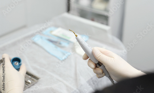 Obraz na plátne hands of doctor hold key nozzle and piezoelectric scaler removal of dental depos