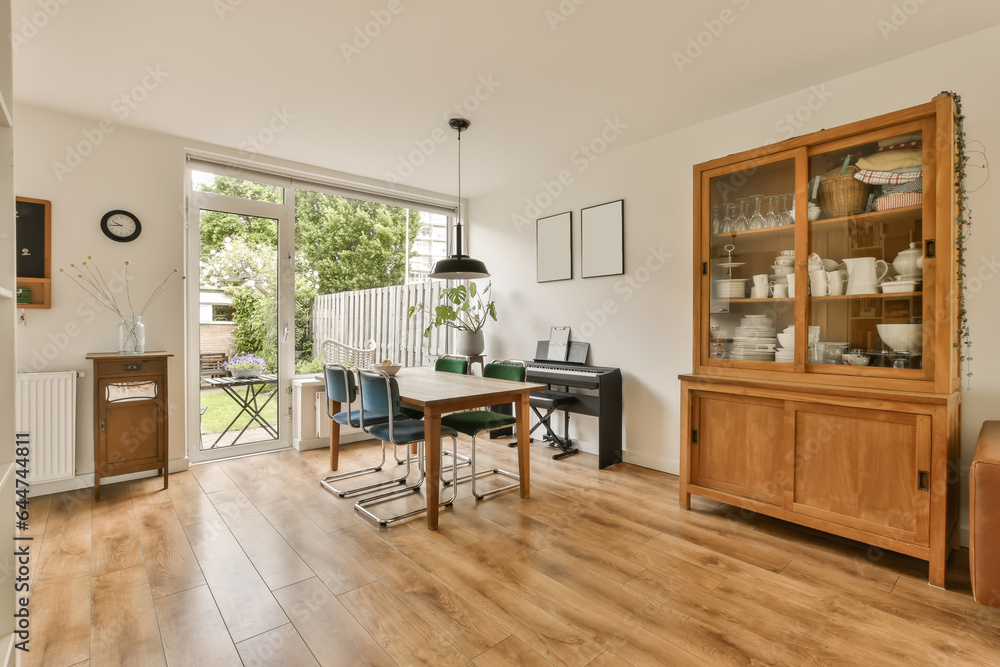 Fototapeta premium a living room with wood flooring and an open glass door leading to the patio area in the back yard