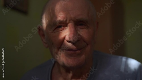 Happy senior man portrait smiling at home. Close-up headshot of 80s years old man on retirement in sunlight. 