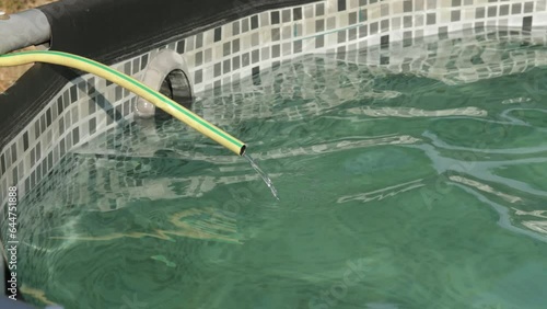 tuyau d'arrosage remplissant une piscine hors sol photo