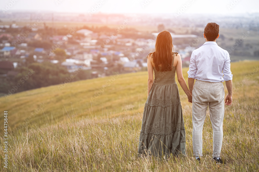 Guy and lady hold hands watching life of environment and city in cloudy weather. Admiration for beauties of nature and picturesque view, sunlight Guy and lady hold hands watching life of environment and city in cloudy weather. Admiration for beauties of nature and picturesque view, sunlight