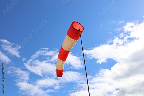 Wind indicator on the background of a blue sky with clouds