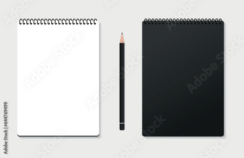 Design Concept - Top view of a black stylish spiral notebook with a black colored pencil isolated on a gray background for the layout