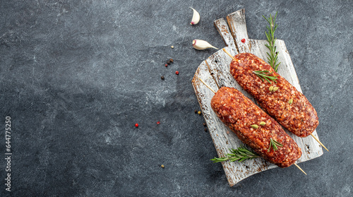lula kebab from raw meat on a wooden board, healthy and balanced eating. Long banner format. top view