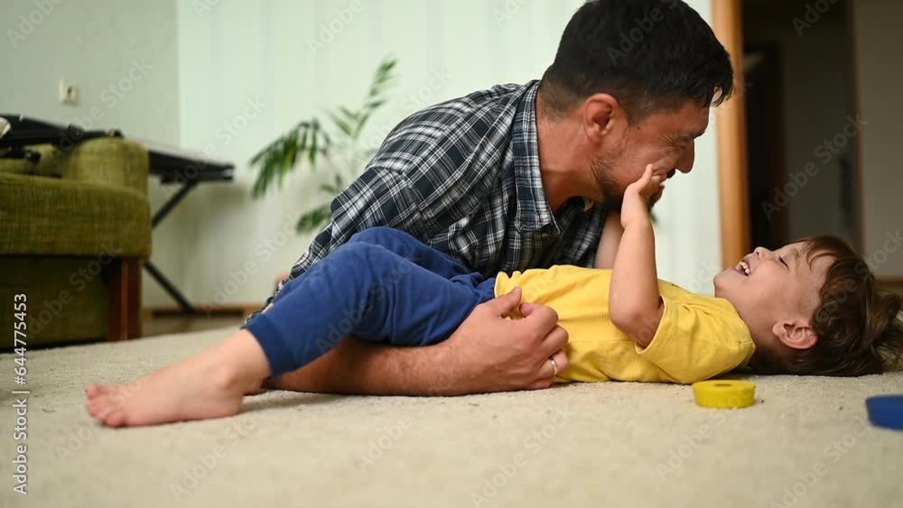 Father and son bond over playtime, sharing laughter and joy on the comfortable living room floor Father and son bond over playtime, sharing laughter and joy on the comfortable living room floor
