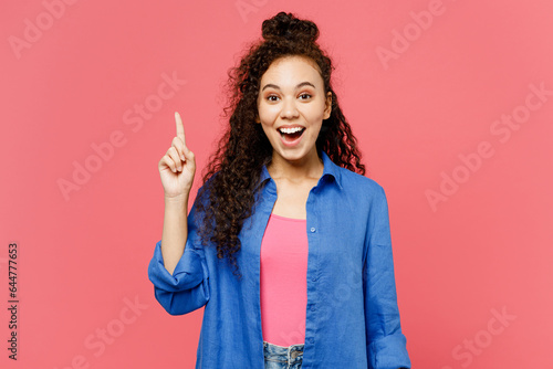 Young insighted smart proactive woman of African American ethnicity she wear blue shirt casual clothes holding index finger up with great new idea isolated on plain pink background. Lifestyle concept.