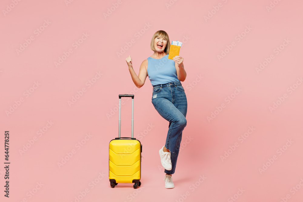 Traveler fun elderly woman wear blue casual clothes hold bag passport ticket isolated on plain pink background. Tourist travel abroad in free spare time rest getaway. Air flight trip journey concept. Traveler fun elderly woman wear blue casual clothes hold bag passport ticket isolated on plain pink background. Tourist travel abroad in free spare time rest getaway. Air flight trip journey concept.
